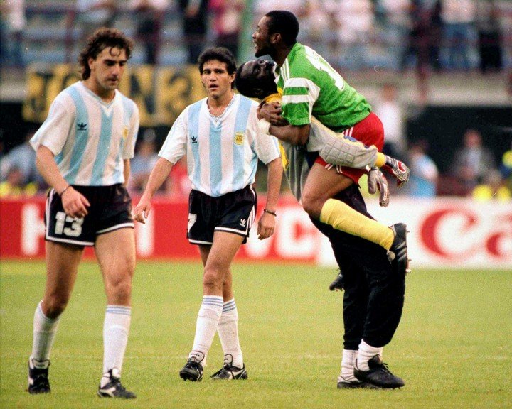 Néstor Lorenzo se lamenta mientras el arquero Thomas N'Kono y el defensor Victor N'Dip celebran la victoria de Camerún sobre Argentina en el Mundial de Italia 1990.