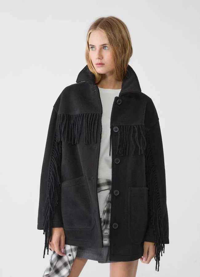 Abrigo negro con detalle de flecos de Stradivarius.