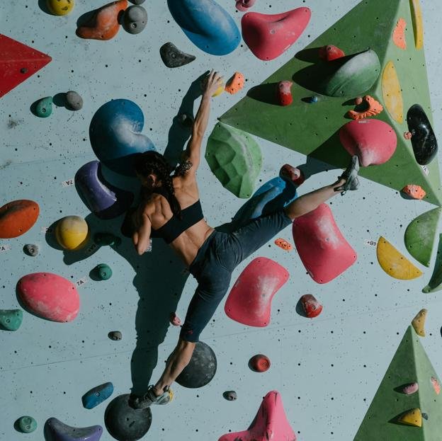 Mujer haciendo escalada indoor. 