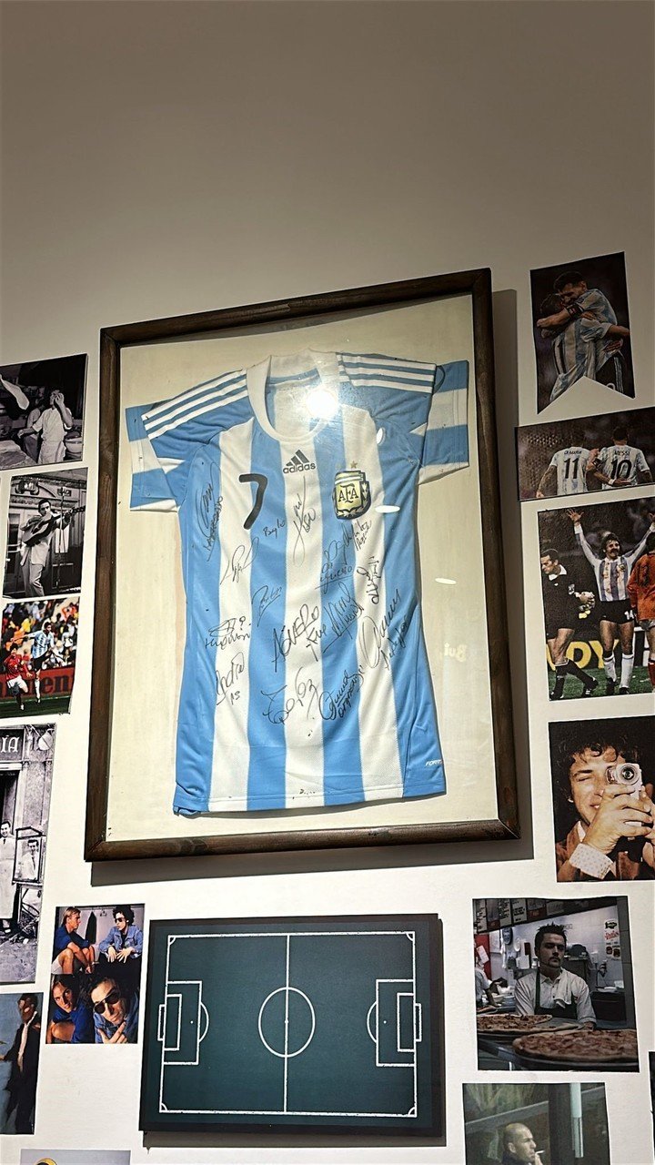 Una camiseta de Ángel di María con la 7 de la Selección, autografiada por él y otros futbolistas del plantel, entre los cuadros de El Centralito.