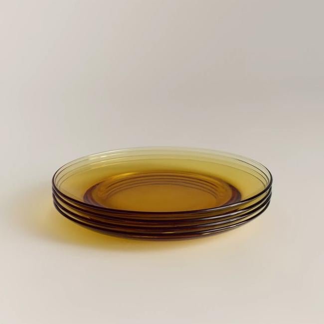 Pack de cuatro platos ámbar de borosilicato de Lefties Home, 11.99 euros.