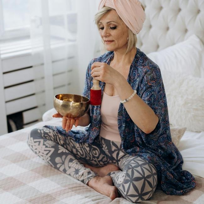 Mujer meditando en casa con incienso.