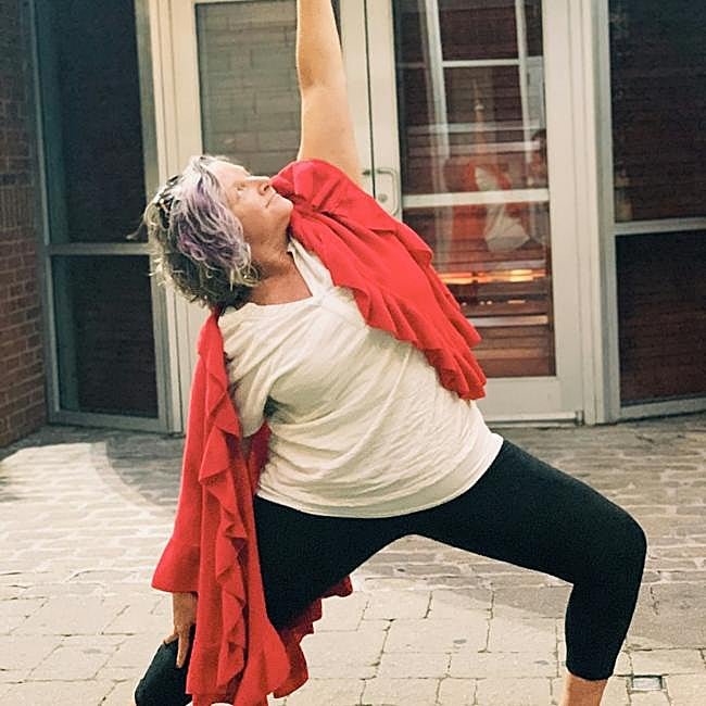 Mujer practicando yoga al aire libre.