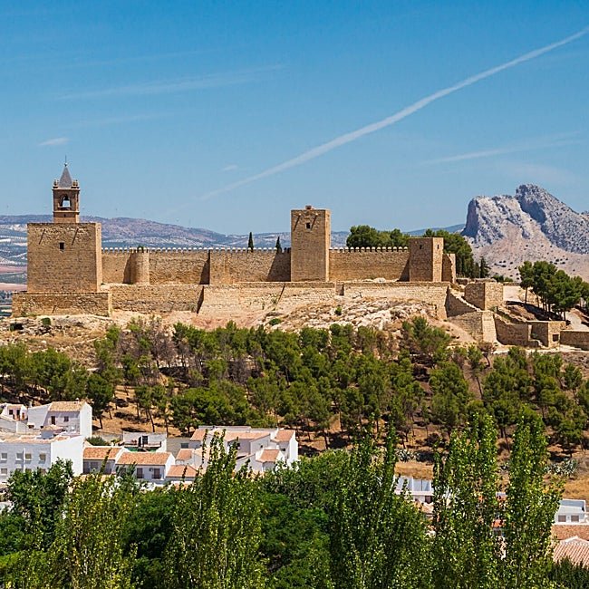 La alcazaba coronando la ciudad blanca con el Peñón de los Enamorados asomando.
