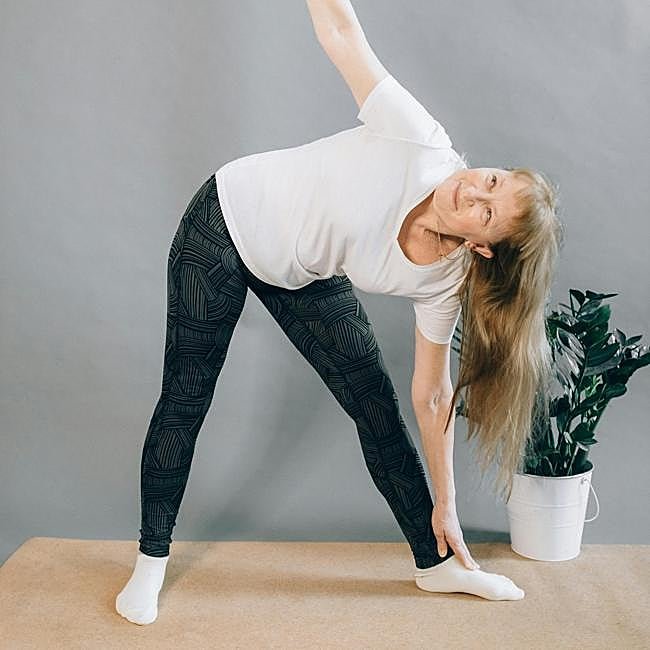 Mujer haciendo ejercicio sobre esterilla.