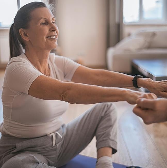 Mujer practicando yoga en casa.