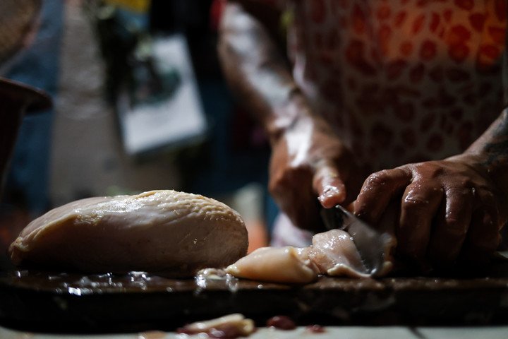 Trozando pollo: los voluntarios se encargan de preparar la cena en la casa natal Diego Armando Maradona. Foto: Antonio Becerra 