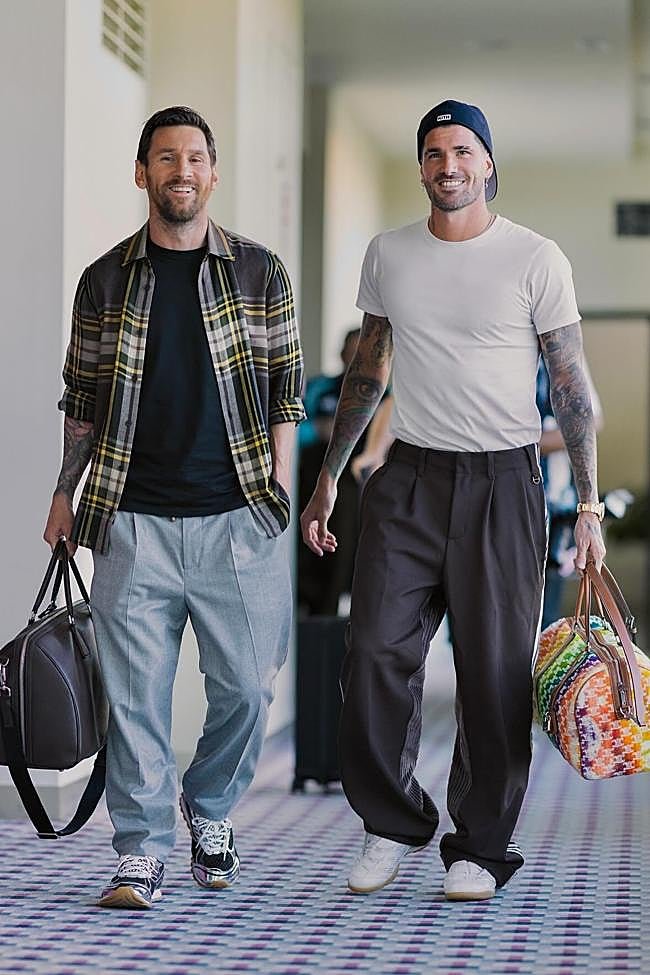 Leo Messi con Bolsa Duffle Saffiano de Prada y Rodrigo de Paul con Medium Voyage Leather Trimmed Wool Weekend Bag de Celine