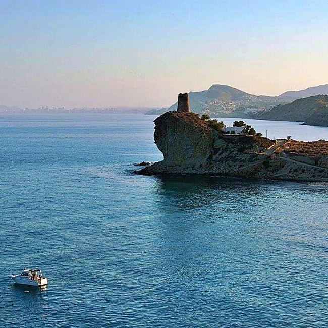 La playa de El Xarco está al amparo de este promontorio con una torre vigía.